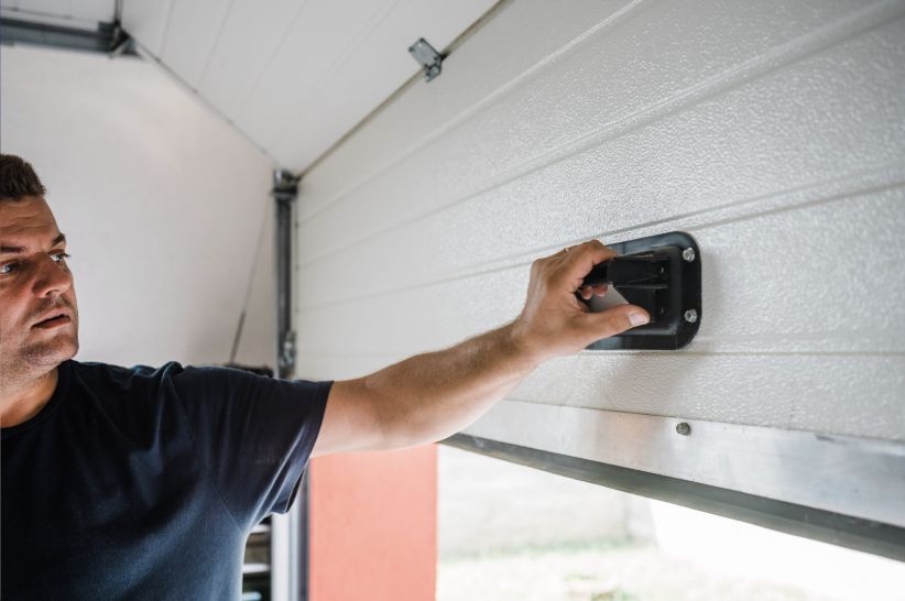 Garage door technician testing a repaired residential door