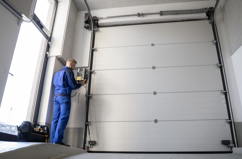 Commercial overhead sectional door being serviced at a Brownsville business