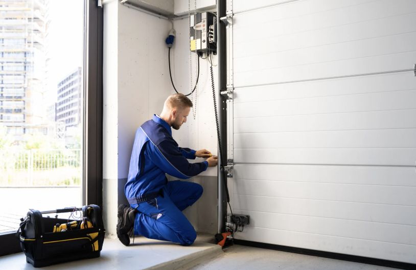 Garage door technician repairing a residential garage door in Brownsville TX